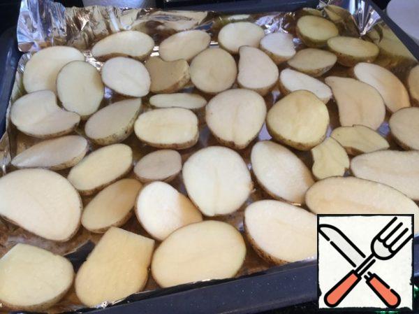 Wash the potatoes well with a brush, cut them into halves and place them on a baking sheet covered with foil.