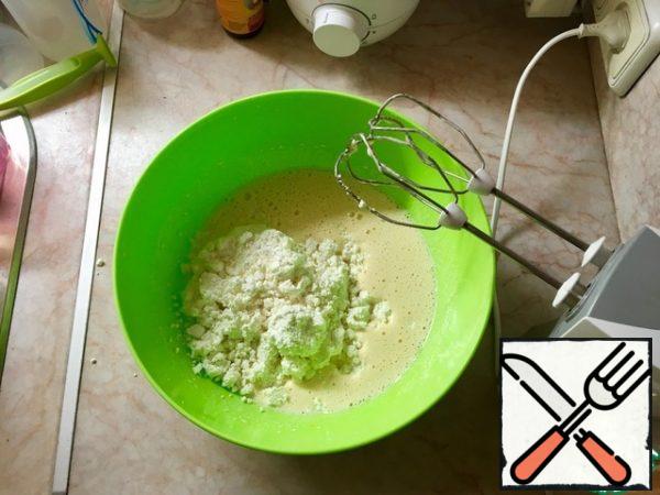 Add cottage cheese to the egg-sugar mass. Stir. If the curd is very lumps-it is better to mix with a mixer.