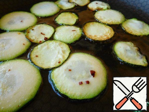 Turn the zucchini over and send the pepper to the pan.