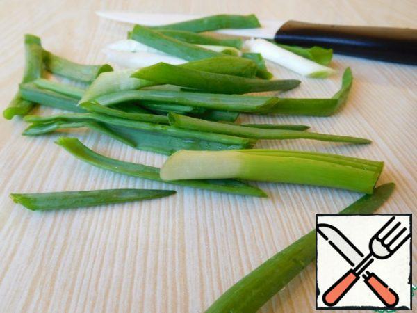 Put the rice to cook. Meanwhile, cut the green onion with feathers about 5-6 cm.
In a frying pan, heat the vegetable oil well and put the onion in it (the process is very fast, it was not possible to photograph it).
I have a small frying pan, the oil was about 4 cm, i.e. the onion should float in it, not fry.