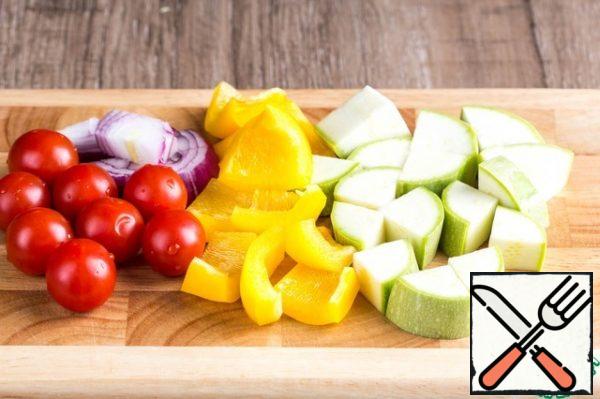 Prepare the vegetables. Thoroughly wash and dry them. Zucchini cut into large cubes, bell pepper first into slices, then into pieces about the size of cubes of zucchini. Cut the onion into thick half-rings and cut them in half.