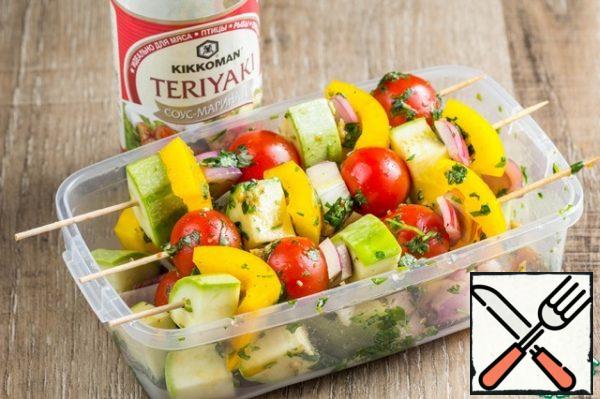 Soak the skewers in water and put the marinated vegetables on them.