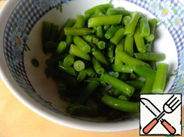 Wash the fresh string beans and cut off the tips. Defrost frozen beans.