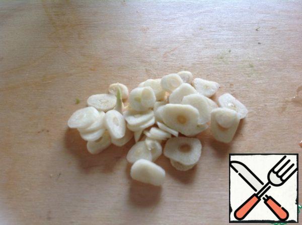 Peel the garlic and cut it into thin slices.