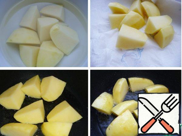 Peel the potatoes, cut into large pieces, rinse with cold water and leave in the water for 10 minutes. Dry with a paper towel and fry in a frying pan in preheated vegetable oil until light brown. Put it on a plate.