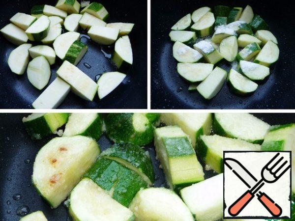 In the same pan, fry the zucchini with rice flour until lightly browned. I don't clean the zucchini completely, I leave some greens, cut into medium pieces.