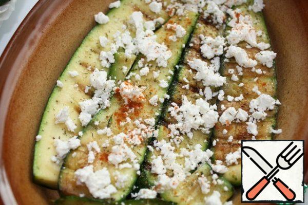 Put the zucchini on the bottom of the mold and sprinkle with crumbled cheese.
Sprinkle with paprika and savory.