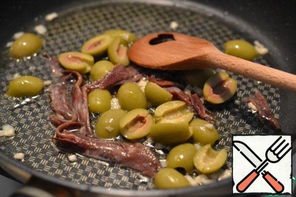 Add the sliced olives and anchovies.
Stir.
