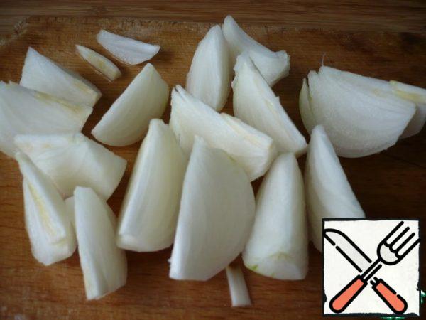 Peel the onion, cut it in half, then cut it into quarters. Now we cut each quarter into halves.