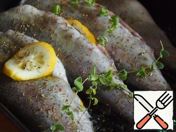 Salt the fish, put a sprig of rosemary and thyme inside. Cut the lemon into rings and also insert one or more rings inside the fish, depending on the size of the fish. In this photo, just a larger fish, mackerel.
