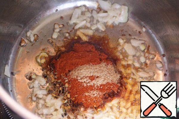 Add red pepper, coriander, some utsho-suneli and cumin to the fried onion, mix and fry for just a few seconds.
For more color brightness, you can add paprika.