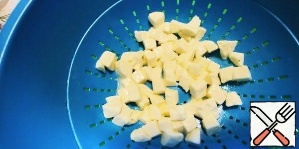 Cut the mozzarella into a cube and leave it on a sieve for 15 minutes. The one that is intended for pizza does not need this procedure.