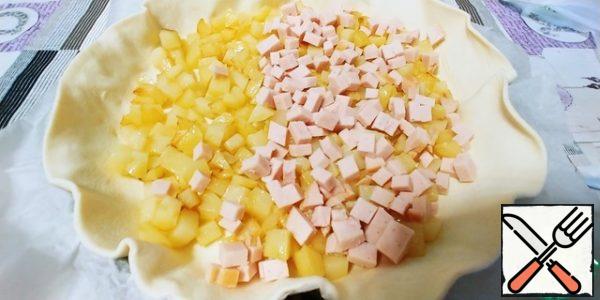 We start to collect our cake (Yes, in Italy, salty pies are often called cakes)
Put the dough in the form directly on the paper. Put the potatoes on top and the sliced prosciutto on top.