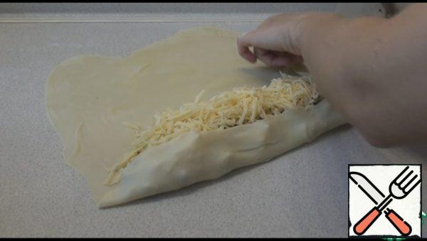 Carefully wrap the edges and roll the dough with the filling into a roll. I covered the baking sheet with parchment, spread the pie on the baking sheet seam down. Similarly, we form the second pie.