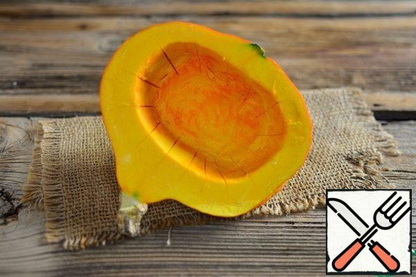 Remove the seed pulp and make shallow incisions inside the pumpkin along the walls, so that the pumpkin is better baked and absorbs the juices from the meat.