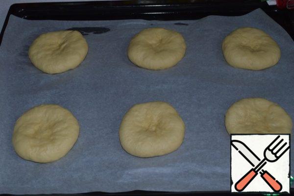 Form round buns, put them on a baking sheet covered with parchment, cover with a towel and leave for 40 minutes. for lifting.