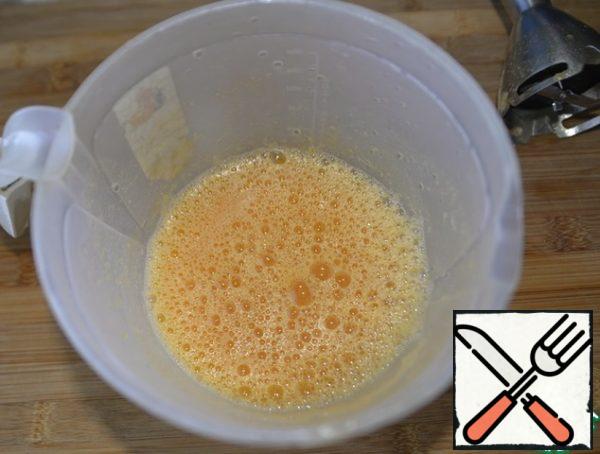 Preparing pancake batter. Pumpkin along with the liquid is punched with a blender.