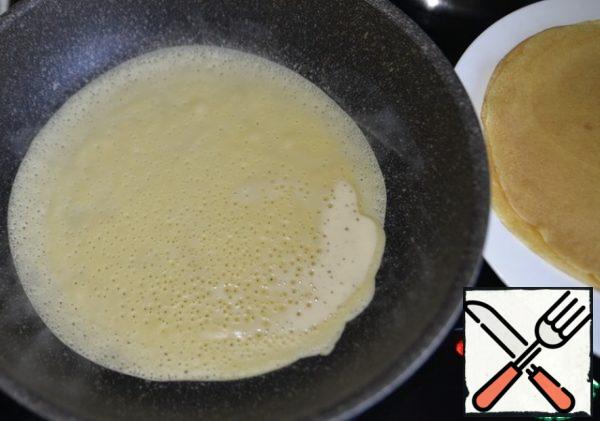 Fry pancakes in the usual way. I have a frying pan 22 cm in diameter. Grease the pan with oil, pour half a ladle of dough, spread evenly over the pan. Fry on medium heat until the dough "grabs", then turn it over.