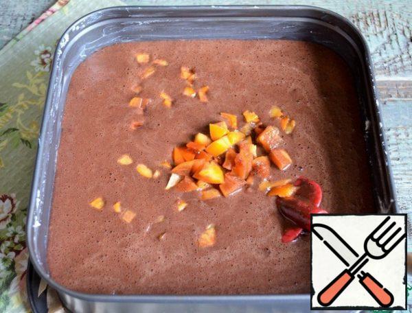 Add the flour mixture to the egg mass. Carefully connect. Pour in the chocolate-butter mixture. Mix until smooth. Form, 24*24, grease with butter, sprinkle with flour. Pour out the dough, pour out the pieces of persimmon, mix gently.