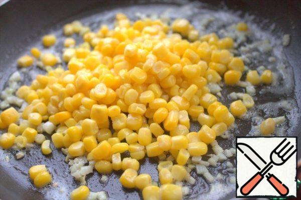 Pour the corn over the garlic.