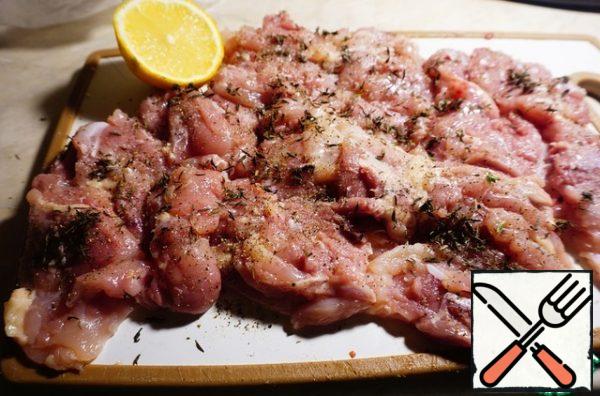 Add salt, pepper, and lemon juice to the meat. With thyme, tear off the leaves and season them with chicken. We massage the meat well and leave it to marinate.