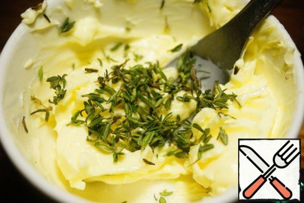 While the quails are soaked, prepare the filling. Add thyme leaves to 80 g of softened butter.