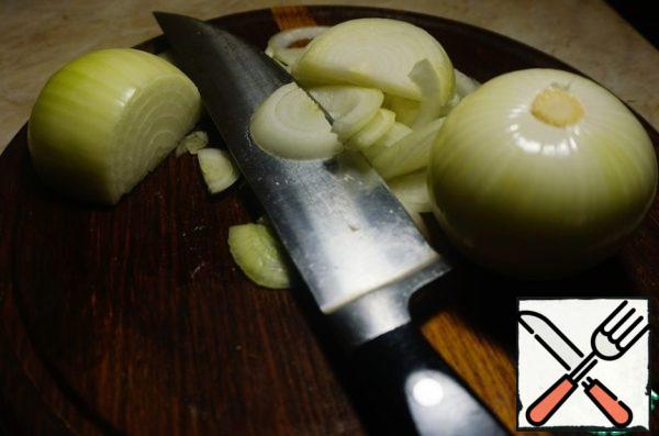 Meanwhile, we prepare the onion side dish. Cut the onion into half rings.