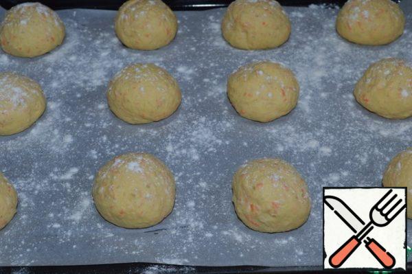 Roll the buns from each part, place on a baking sheet covered with parchment, and sprinkle with flour.
Cover with a towel and send to a warm place for 30 minutes.
