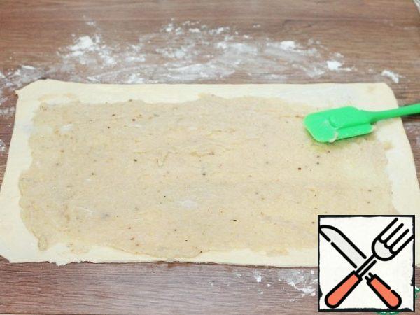 Spread evenly on the dough layer filling, 1/2 part.