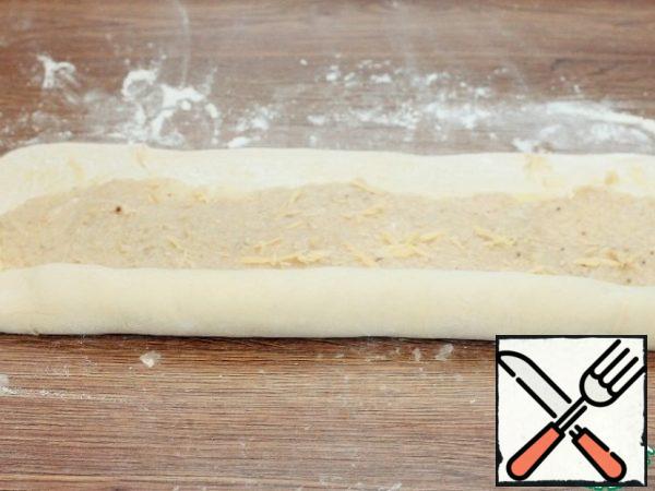 Fold the dough layer with the filling into a roll.