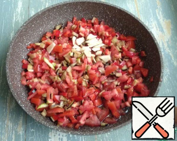 Next, prepare the sauce. Wash the tomatoes and cut them into cubes. Wash the bell pepper, remove the seeds, and cut into cubes. Peel the garlic, wash it and cut it into plates. Combine everything in a frying pan. Add olive oil, soy sauce, and ground pepper. If there are extra zucchini and eggplant, they can also be finely chopped and added to the sauce. Simmer over medium heat for 7 minutes.
I sometimes add a tablespoon of sugar, it turns out a little sweet taste, but this is optional)