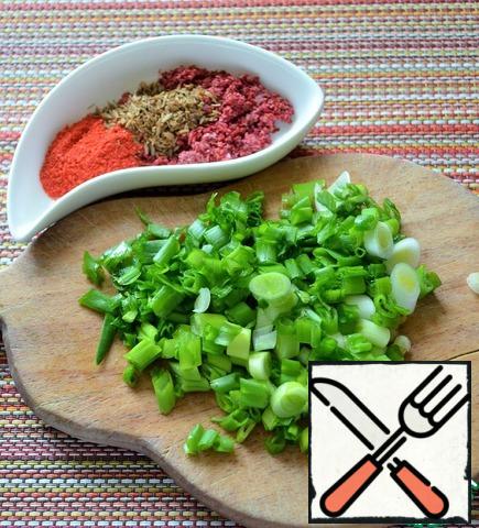 Grind the cumin in a mortar, prepare other spices, wash the green onions, dry them, and cut them. Add the spices, part of the onion, and Bay leaf to the soup, let it boil and remove from the heat.
