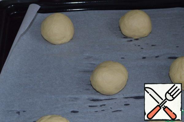Knead the dough well and divide it into 12 parts.
Roll up round buns and place them on a baking sheet covered with parchment.
Cover with a towel and send to proofing for 30 minutes.