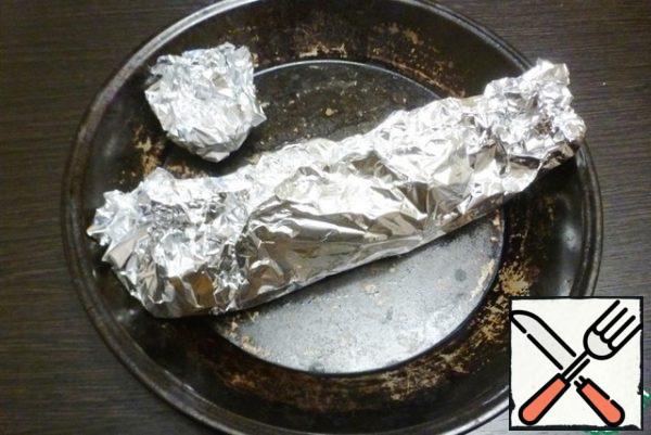 To wrap the fish and garlic in the foil.