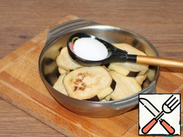 Put the eggplant in a bowl and pour boiling water, add salt (1 tbsp). Cover the bowl with a lid and set aside for a time from 30 minutes to 1 hour, it all depends on the variety of eggplant. Then wash the eggplant circles, squeeze them out and put them on a napkin.
