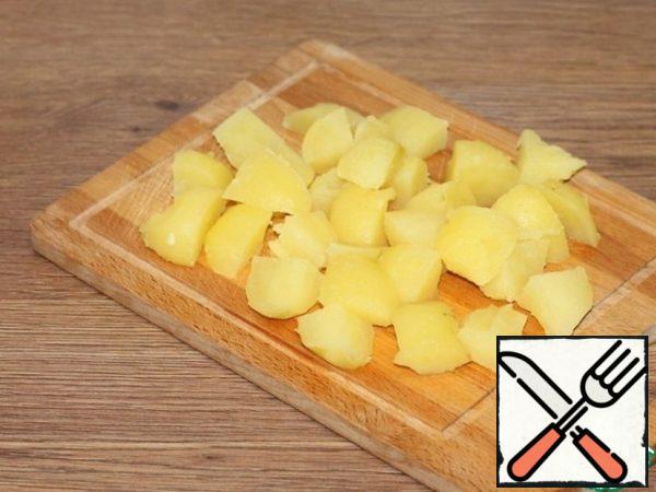Boiled potatoes are peeled from the skin and cut into slices.