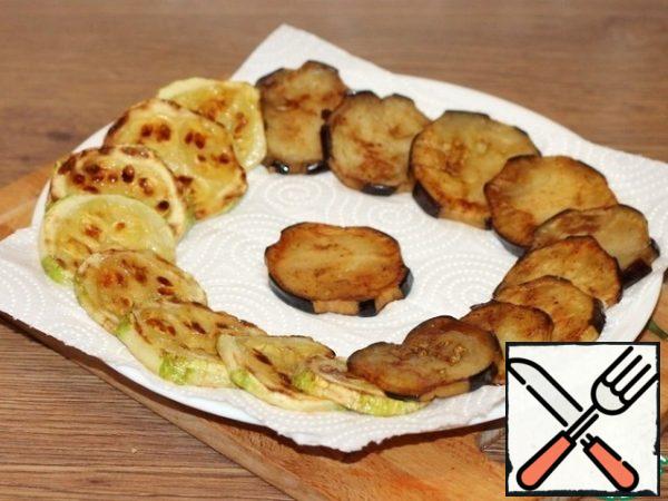 Eggplant and zucchini slices are fried on both sides in vegetable oil and spread on a paper napkin. We salt the vegetables, only when we turn them over, only one side.