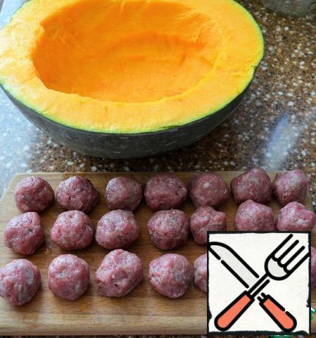 Cut the pumpkin in half, clean the seeds and part of the pulp, make it stable by cutting the bottom. Make meatballs from minced meat and fry in 1 tablespoon of vegetable oil.