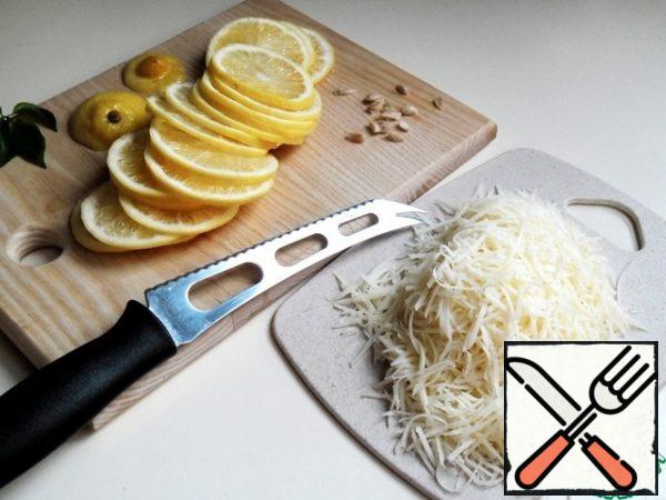 Cut the cooled lemon into thin rings, immediately removing the seeds. I was comfortable cutting and removing with a cheese knife.
Grate the cheese with fine shavings.
