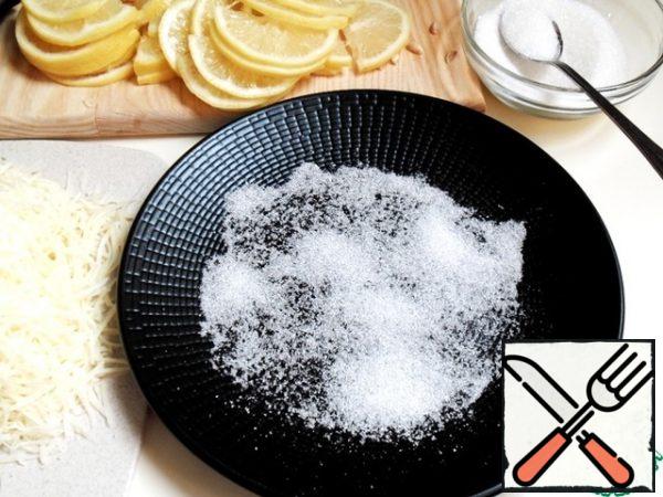 If the lemon is large, cut the lemon rings into halves.
On a flat plate, pour a little sugar so that the slices are soaked from the bottom.