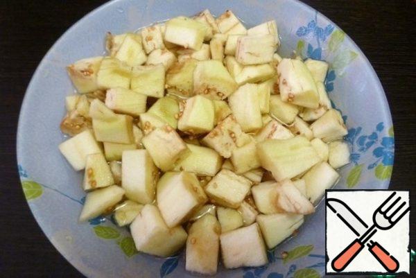 Peel the eggplant and cut it into cubes. Dip them in lemon-acidified water for 15-20 minutes.