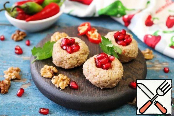 Put in the refrigerator to cool. To serve, you need to roll balls the size of a large walnut and flatten. Make a small dent on top and put the pomegranate seeds in it. You can decorate with herbs or halves of walnuts.
