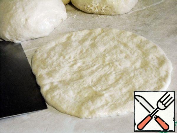 Now form a tortilla from each bun of dough, stretching it with your hands to the desired diameter, my tortillas have 16-17 cm, and the thickness is 1 cm.