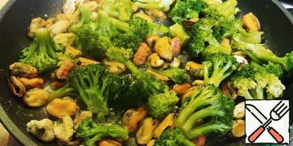 Boil the broccoli for 2 minutes in boiling water and add to the clams. I removed the garlic.
The recipe suggested stewing broccoli in a frying pan for 10 minutes and then adding clams.
Dip the spaghetti in boiling salted water, cook for the time indicated on the package, even a minute less, al dente)
