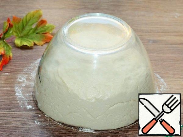 In 30 minutes, the dough has risen, it has become smooth, shiny and does not stick to your hands.
Then knead the dough.