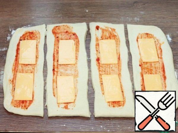 Grease the tortillas with sauce and spread the cheese plates.