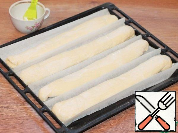 Put the blanks on greased baking paper and cover with a towel. Leave the bowl in a warm place until the dough increases by 2 times, for 20-30 minutes.
Turn on the oven at t 220 C.