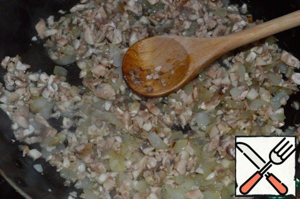 Finely chop the onion and fry it until Golden brown.
Add chopped mushrooms.
Fry for 2-3 minutes.