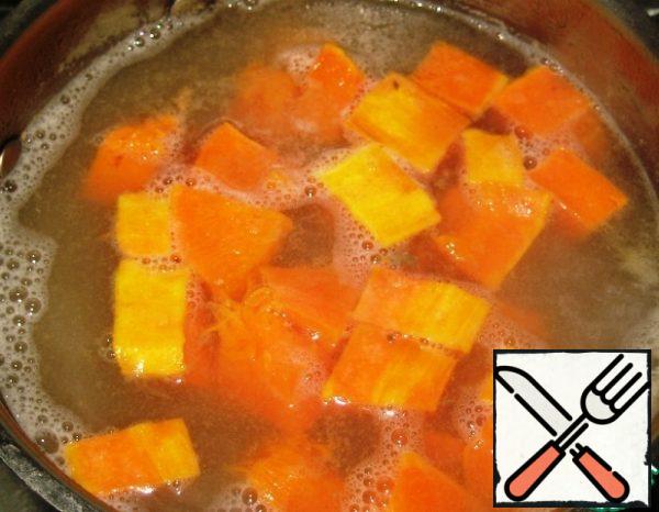 When the broth with potatoes boils, reduce the heat under the saucepan, cook for 4-5 minutes. Then add the pumpkin slices.