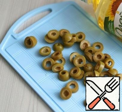 Cut green olives into rings.
